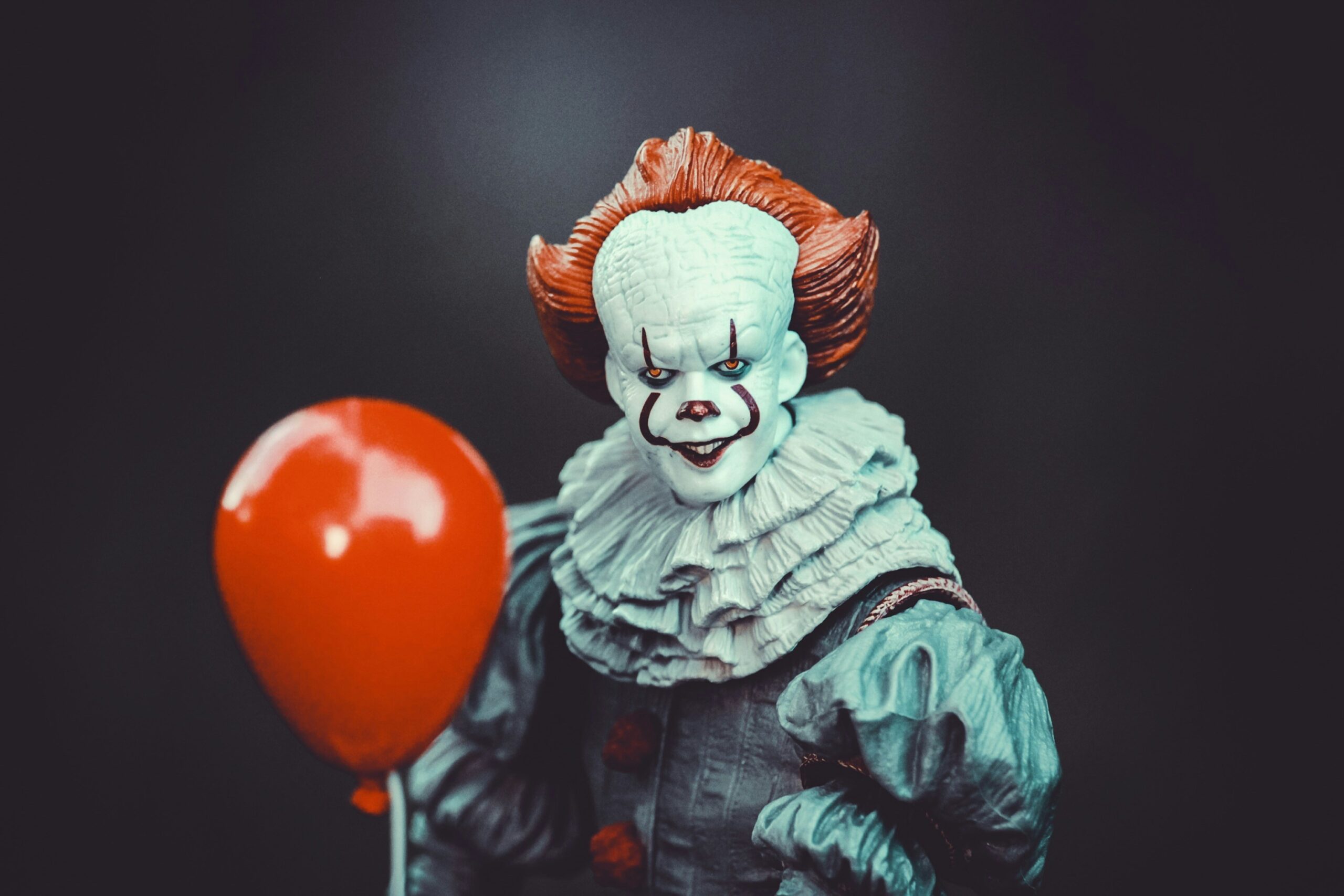 A toy version of Pennywise the Clown from Stephen King's IT, holding a red balloon.