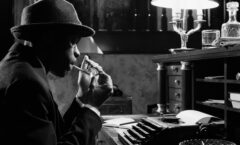 A noir detective at a typewriter. Black and white.